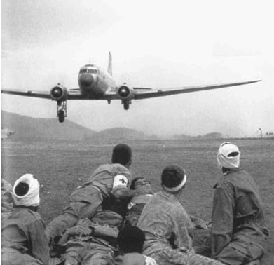 French troops watching a medical evacuation aircraft take off from the Điện Biên Phủ battlefield.